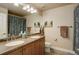 Bathroom featuring a double vanity, granite counters, a mirror and a toilet at 4810 Mountain Gold Run, Broomfield, CO 80023