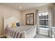Bright bedroom featuring a large window, striped bedding, and hardwood flooring at 4810 Mountain Gold Run, Broomfield, CO 80023