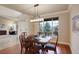 Sunlit dining room with wooden table, chairs, and a view of the outdoors through a large window at 4810 Mountain Gold Run, Broomfield, CO 80023