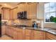 Close-up of kitchen features stainless appliances, gas cooktop, designer backsplash, and ample wood cabinets at 4810 Mountain Gold Run, Broomfield, CO 80023