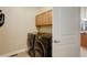 Laundry room featuring front loading washer and dryer, cabinets and tile flooring at 4810 Mountain Gold Run, Broomfield, CO 80023