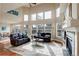 Open-concept living room with tall windows, hardwood floors, fireplace and comfortable seating at 4810 Mountain Gold Run, Broomfield, CO 80023