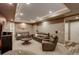 Cozy living room featuring plush leather seating, neutral walls, and a tray ceiling with recessed lighting at 4810 Mountain Gold Run, Broomfield, CO 80023