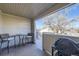 View of a covered balcony with a table, two chairs, and a grill at 5075 Garrison St # 3, Wheat Ridge, CO 80033