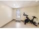 Basement area with tile flooring, an exercise bike, and a walkout door at 5075 Garrison St # 3, Wheat Ridge, CO 80033