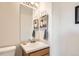 Clean half bathroom featuring neutral colors, updated light fixture, and decorative artwork at 5075 Garrison St # 3, Wheat Ridge, CO 80033