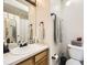 Bathroom featuring a wooden vanity, updated fixtures, and a framed mirror at 5075 Garrison St # 3, Wheat Ridge, CO 80033