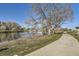 View of the community walking path next to the pond, and surrounded by trees at 5075 Garrison St # 3, Wheat Ridge, CO 80033