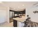 Open concept kitchen with black cabinets, stainless appliances and granite counters plus eat-in bar seating at 5075 Garrison St # 3, Wheat Ridge, CO 80033