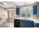 The kitchen features white countertops, blue cabinets, modern appliances, and wood look floors at 19876 E Brunswick Dr, Aurora, CO 80013