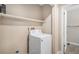 This laundry room features a white washing machine and a shelf at 19876 E Brunswick Dr, Aurora, CO 80013