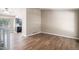 Open living room with wood floors, neutral walls, a large picture window, and views of the kitchen at 19876 E Brunswick Dr, Aurora, CO 80013