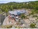 Wide aerial shot of a home featuring solar panels, a deck, stone landscaping, and surrounding natural beauty at 6767 Timbers Dr, Evergreen, CO 80439