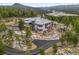 Majestic aerial view of home surrounded by trees, with private driveway and stone landscaping at 6767 Timbers Dr, Evergreen, CO 80439