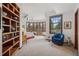 Bright bedroom with a bay window, hardwood floors, and built in shelving at 6767 Timbers Dr, Evergreen, CO 80439