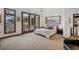 Bright bedroom with balcony access features a ceiling fan, landscape painting, and a comfortable king bed at 6767 Timbers Dr, Evergreen, CO 80439