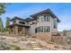 Exterior view of home with stone accents, multiple windows, an outdoor patio, and unique architectural design at 6767 Timbers Dr, Evergreen, CO 80439