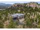 Stunning luxury home with mountain views surrounded by lush trees and unique rock formations at 6767 Timbers Dr, Evergreen, CO 80439