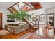 Grand foyer showcasing a beautiful indoor tree, unique stone planter, and natural light from the upper level and surrounding windows at 6767 Timbers Dr, Evergreen, CO 80439