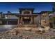 Stunning home featuring a stone facade, grand entrance with stone pillars, and beautiful rock landscaping at 6767 Timbers Dr, Evergreen, CO 80439