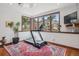 Bright gym featuring large windows with scenic views, a modern treadmill, and elegant decor on a hardwood floor with rug at 6767 Timbers Dr, Evergreen, CO 80439