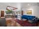 Open-concept living room with a unique foyer, hardwood floors, and stylish blue furnishings at 6767 Timbers Dr, Evergreen, CO 80439