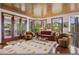 Inviting living room features wood ceiling, plush seating, many windows, and access to a deck with beautiful views at 6767 Timbers Dr, Evergreen, CO 80439