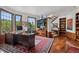 Well-lit office features a large desk, many windows, wood floors, built-in bookcase, and grand stair access at 6767 Timbers Dr, Evergreen, CO 80439