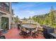 Outdoor deck features seating, an outdoor dining table, and incredible scenery with natural rock outcroppings and trees at 6767 Timbers Dr, Evergreen, CO 80439