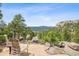 Serene outdoor patio featuring stunning mountain views and comfortable seating area at 6767 Timbers Dr, Evergreen, CO 80439