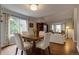 Cozy dining area featuring a wooden table, white chairs, hardwood floors, and a bright, airy ambiance at 6255 Collegiate Dr, Highlands Ranch, CO 80130