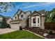 Home exterior showcasing a two-story design with brick and siding, a bay window, an American flag, and a well-manicured lawn at 6255 Collegiate Dr, Highlands Ranch, CO 80130
