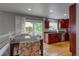 Eat in kitchen featuring cherry cabinets, dark countertops, backsplash, and adjacent access to a patio with natural light at 6255 Collegiate Dr, Highlands Ranch, CO 80130