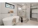 Luxurious bathroom featuring a standalone tub, walk-in shower, and sleek modern finishes at 2391 King St, Denver, CO 80211