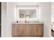 Modern bathroom with illuminated mirror, dual sinks, and stylish wood grain vanity offers a luxurious feel at 2391 King St, Denver, CO 80211