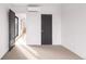 Bedroom with neutral carpet and a view to a bright hall with an opened black door at 2391 King St, Denver, CO 80211