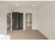 Empty bedroom with carpeted floor, white walls, black doorframes, and access to the bathroom at 2391 King St, Denver, CO 80211