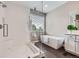 Bathroom with a modern design, featuring a glass shower, soaking tub, and white cabinetry at 8469 Winter Berry Dr, Castle Pines, CO 80108