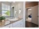 A well-lit bathroom with granite countertops, a bright window, and a doorway into a bedroom at 8469 Winter Berry Dr, Castle Pines, CO 80108