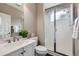Bathroom with white vanity, quartz countertop, frosted glass shower doors, and neutral wall color at 8469 Winter Berry Dr, Castle Pines, CO 80108