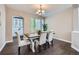 Bright dining room featuring a chandelier, dark floors, and arched doorway to kitchen at 8469 Winter Berry Dr, Castle Pines, CO 80108
