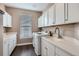 A well-lit laundry room with plenty of white storage cabinets, sink, and new appliances at 8469 Winter Berry Dr, Castle Pines, CO 80108