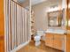Cozy bathroom with a shower/tub combo, a wood vanity and decorative mirror, and tiled flooring at 1374 Crested Butte Ct, Evergreen, CO 80439