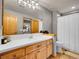 Bathroom with wood cabinets, and shower with tile at 1374 Crested Butte Ct, Evergreen, CO 80439