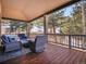 This covered porch features comfortable seating, a fire pit, and scenic views of the surrounding wooded landscape at 1374 Crested Butte Ct, Evergreen, CO 80439