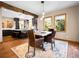 The dining room features hardwood floors, a rug, a rustic wood table with leather chairs, and access to the kitchen at 1374 Crested Butte Ct, Evergreen, CO 80439