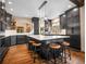 Contemporary kitchen boasts an expansive island with seating, dark cabinetry, modern appliances, and hardwood floors at 1374 Crested Butte Ct, Evergreen, CO 80439