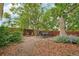 Secluded backyard features mature trees, landscaping, wood fencing, and patio seating at 2203 S Lincoln St, Denver, CO 80210