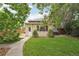 Charming backyard showing grass area, sidewalk, and exterior of the home at 2203 S Lincoln St, Denver, CO 80210
