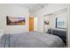Bedroom featuring wood floors, sliding closet doors, queen bed, and a mountain scene wall art at 2203 S Lincoln St, Denver, CO 80210